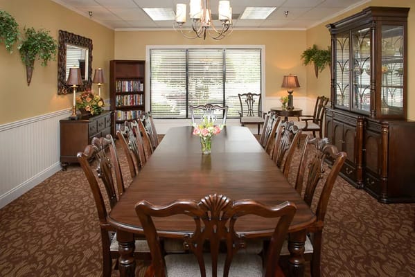 Elegant dining room with a long wooden table and floral centerpiece.
