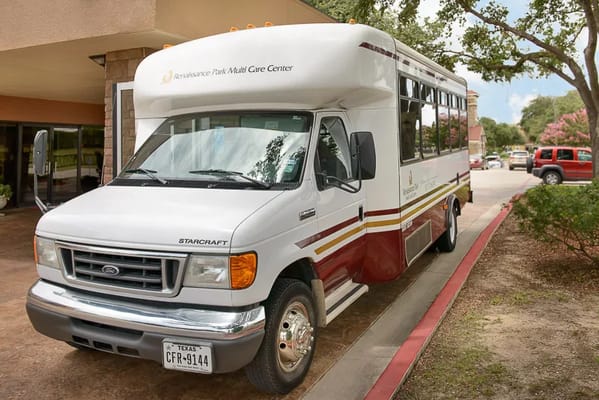 White shuttle bus parked outside Renaissance Park Multi Care Center