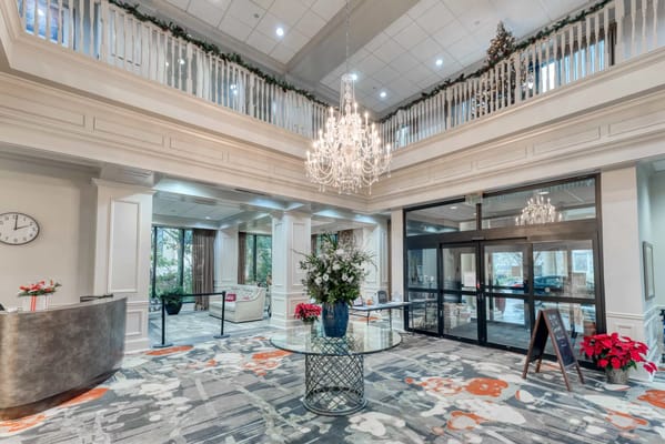 Spacious lobby with chandelier and floral arrangement