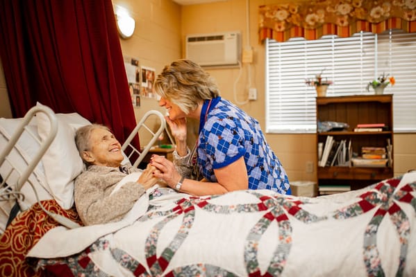 Staff member interacting with a resident in a bedroom