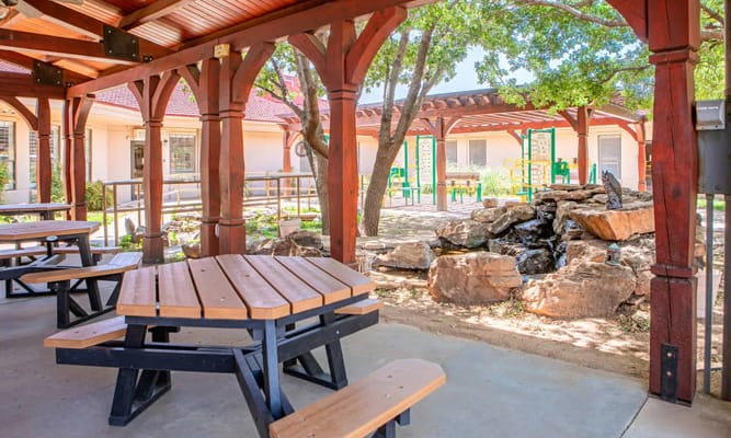 Outdoor seating area with picnic tables and trees