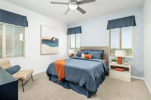 A stylish bedroom featuring a blue bedspread and decorative pillows