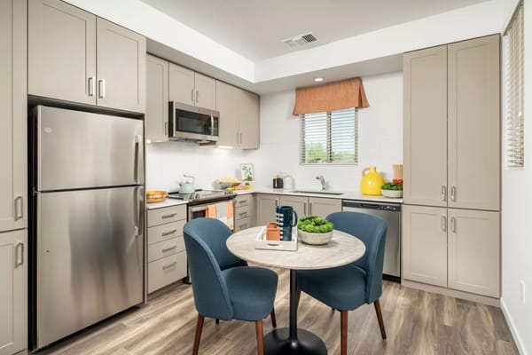 Bright and modern kitchen with stainless steel appliances and dining area.