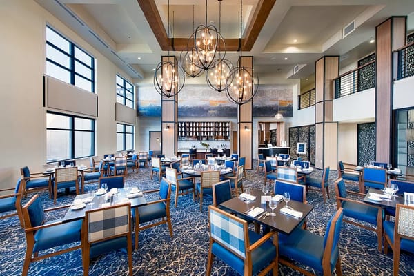 Spacious dining room with blue chairs and large windows
