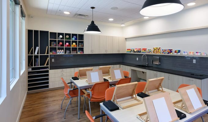 A bright activity room with tables and art supplies