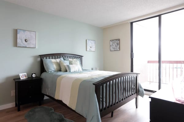 Cozy resident room with a bed and balcony access