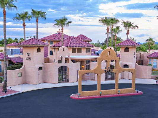 Entrance to Arbor Ridge with palm trees and decorative architecture