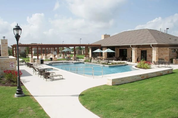 Outdoor pool area with lounge chairs and umbrellas