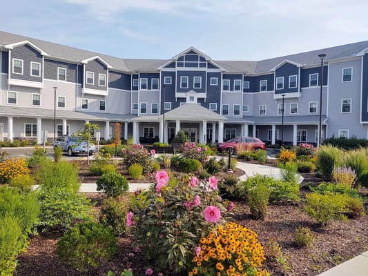 Front view of River Mills Assisted Living with landscaped garden and flowers