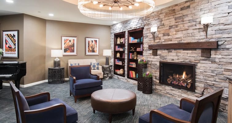 Comfortable seating area with fireplace and bookshelves in the lobby.