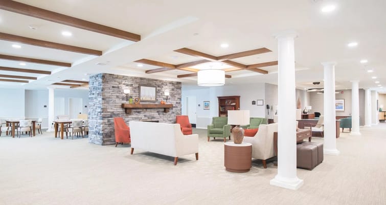 Bright and inviting lounge area with comfortable seating and a stone fireplace.