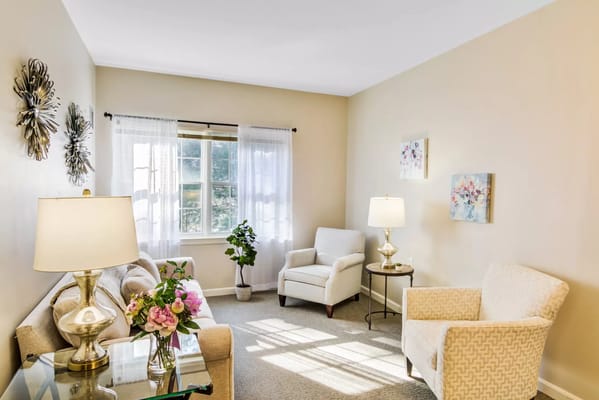 Well-lit living room with comfortable seating and decorative elements