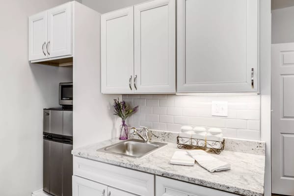 Well-equipped kitchen with white cabinets and stainless steel appliances