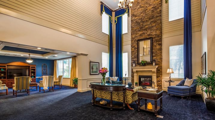 Cozy lounge area with chairs, a fireplace, and large windows