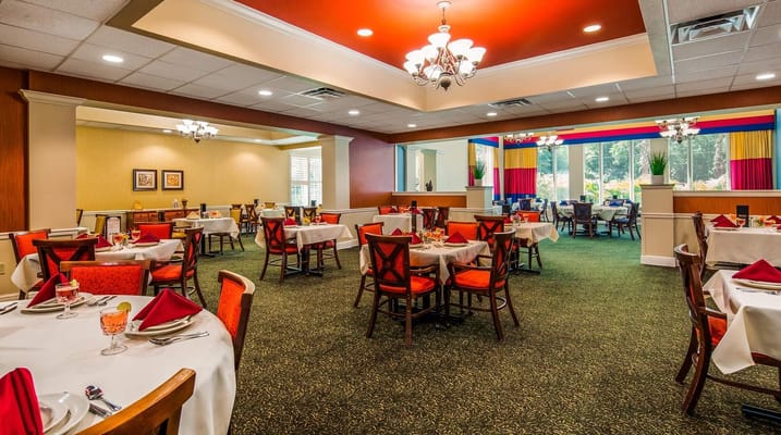 Brightly decorated dining room with tables set for dining.