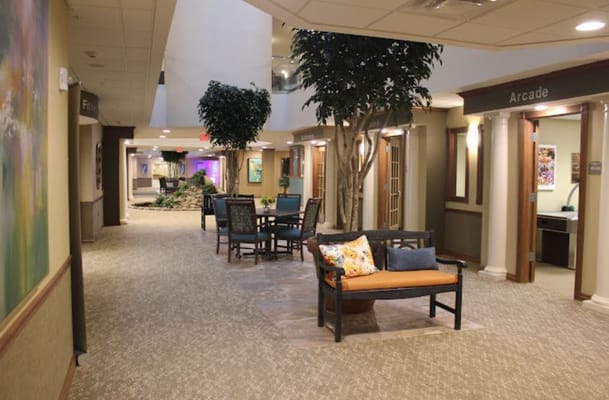Spacious hallway with seating areas and greenery at Riverstone Retirement Community