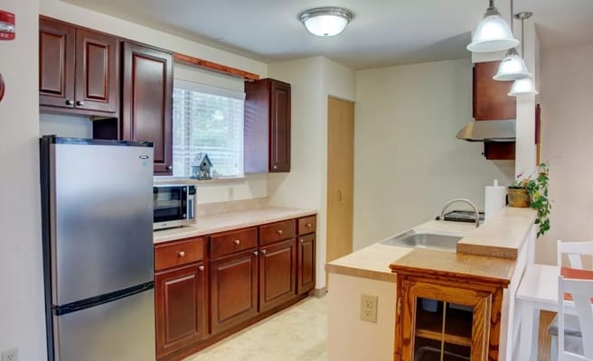 Spacious kitchen with stainless steel appliances and wooden cabinets