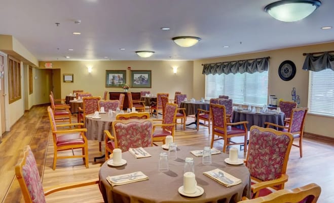 Dining room with tables and chairs at Robin Way senior living facility