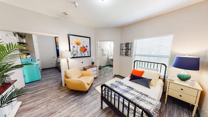 A cozy resident room with bed and seating area