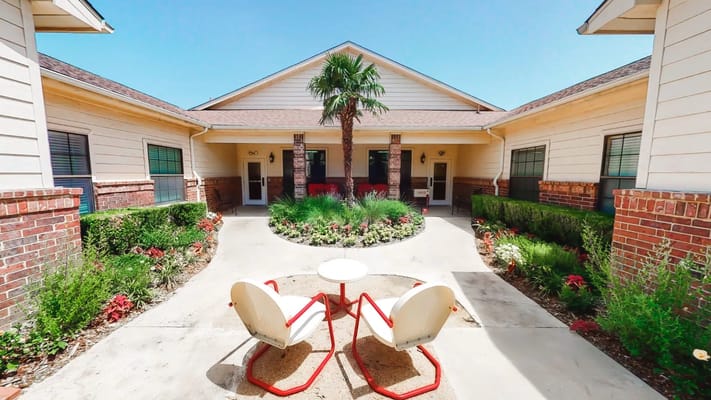 Courtyard with chairs and tropical plants outside the building