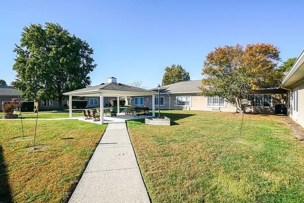 Outdoor seating area under a gazebo with well-maintained lawn