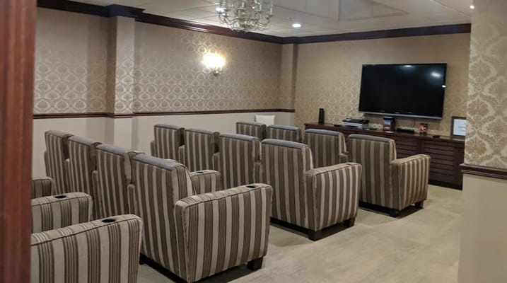 Cozy theater room with striped chairs and a TV
