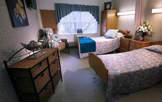 Comfortable shared bedroom with floral bedding and natural light.