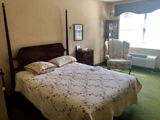 Cozy resident room with a bed and armchair