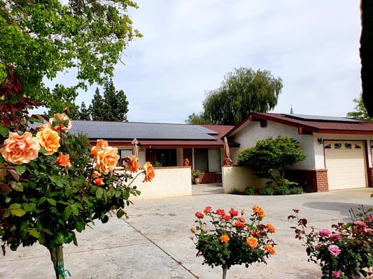 View of the front garden with blooming roses and the facility building.