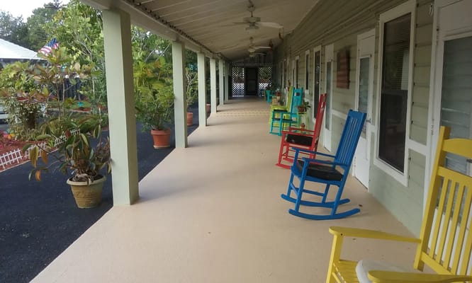 Vibrant rocking chairs line the porch of Rustic Retreat.
