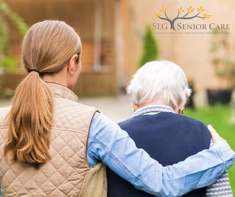 Caregiver comforting a senior resident outdoors