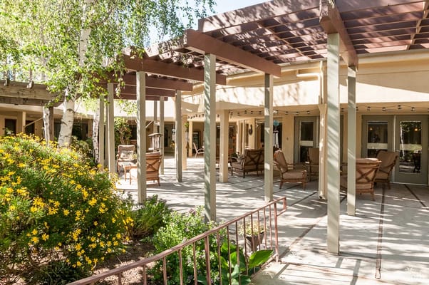 Patio area with seating and flowering plants in Sunny View Retirement Community