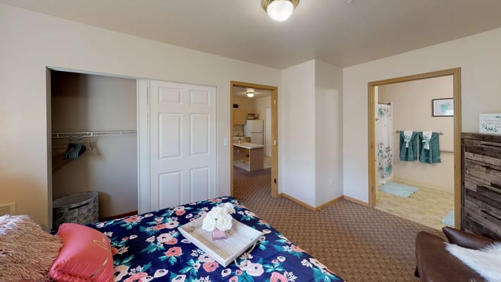 Interior view of a private resident room with floral bedding