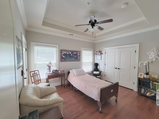 Interior of a serene bedroom with a bed and seating area.