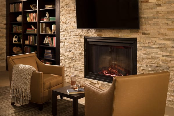 Comfortable chairs next to a fireplace in a lounge area