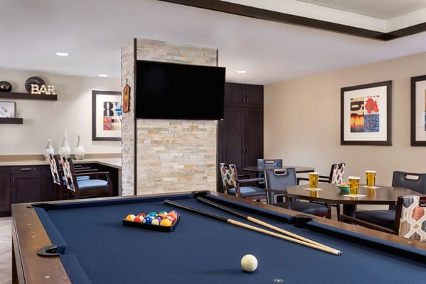 A pool table with balls and cues in a cozy game room
