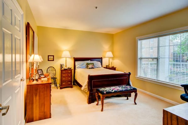 Bright, inviting bedroom with a bed, dresser, and window.