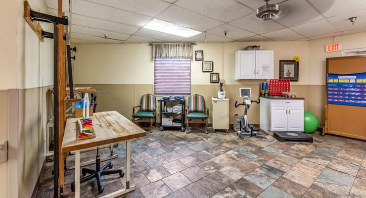 A therapy room with exercise equipment and seating area