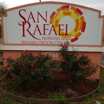 Sign for San Rafael Nursing and Rehabilitation Center with flowers in foreground