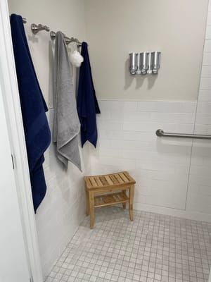 Shower room with towels and a wooden stool
