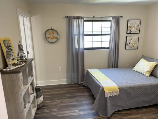 Comfortable bedroom with a bed, decorative pillows, and natural light