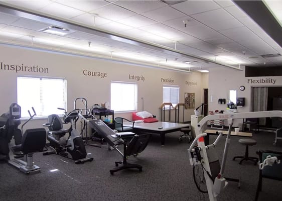 Therapy room featuring exercise equipment and motivational quotes on the walls.