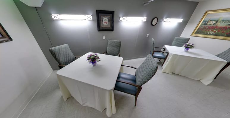 Seating area with tables and floral arrangements in a common room.