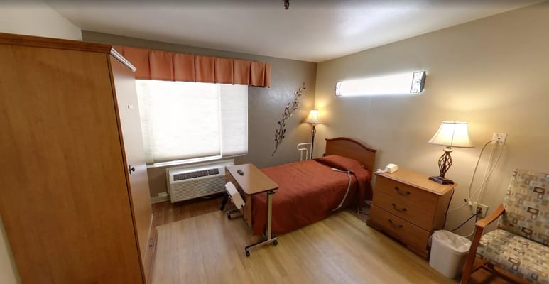 A cozy bedroom featuring a bed, bedside table, and a lamp in Sandstone Richfield.