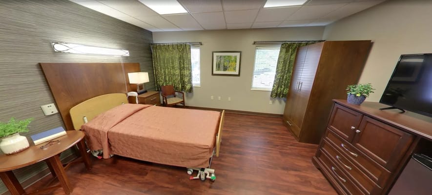 A cozy bedroom with a bed, nightstand, and dresser.