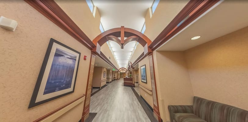 Brightly lit hallway featuring artwork and seating areas