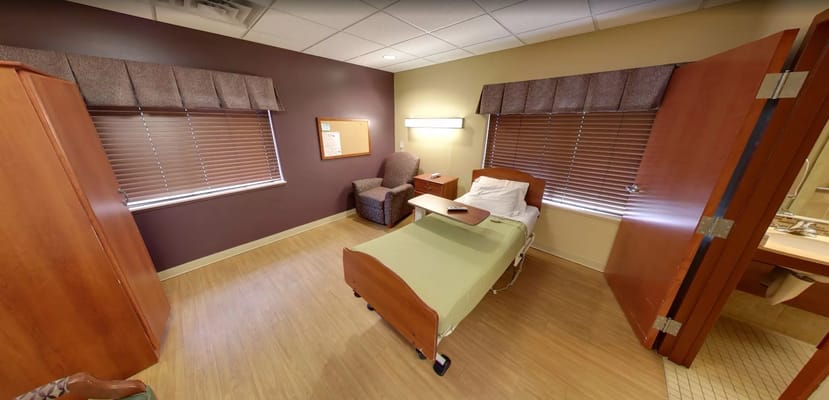 Brightly lit bedroom with a bed and armchair