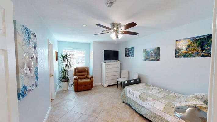 A private room in a senior living facility with decor and furniture