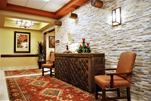 Cozy lobby area with wooden furniture and decorative stone wall