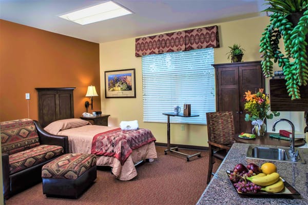Comfortable bedroom featuring a bed, seating area, and kitchenette